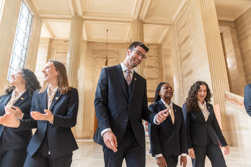 Un groupe de guides-interprètes de la Cour suprême du Canada qui marchent ensemble en riant dans le hall d’honneur.