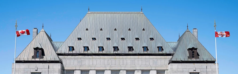The Canadian flag and the Supreme Court of Canada flag flying in front of the Court building