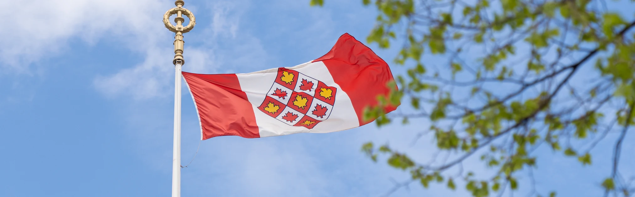 The Supreme Court of Canada flag flying against a blue sky
