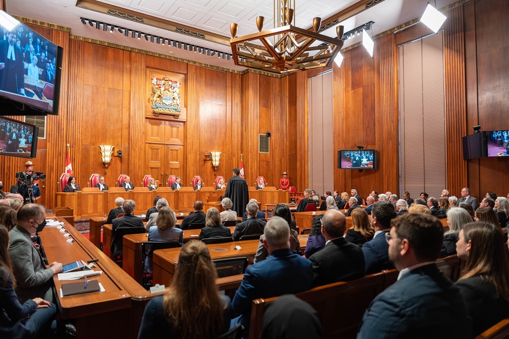 La cérémonie dans la salle d’audience principale. Le ministre de la Justice, Sean Fraser, s’adresse au banc des juges à partir du podium. Les tribunes des avocats et du public sont pleines de spectateurs.