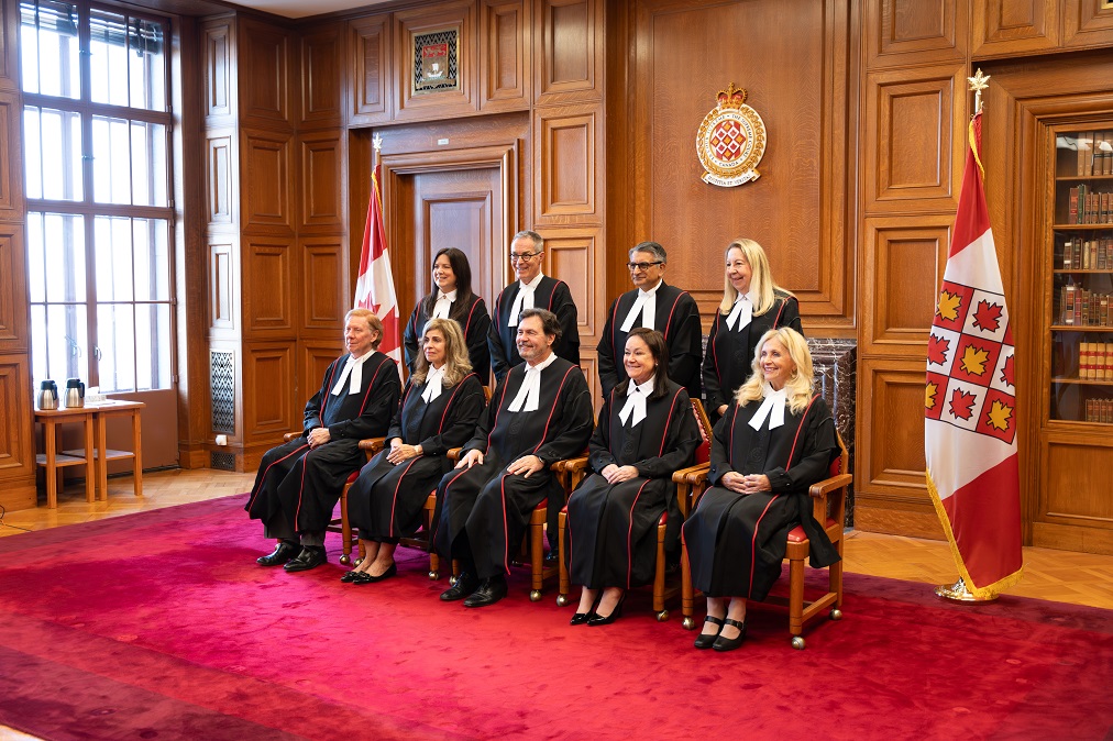 Une photo de groupe des juges portant leurs nouvelles toges d’apparat. Les toges sont noires avec une bordure rouge et des détails brodés en noir.