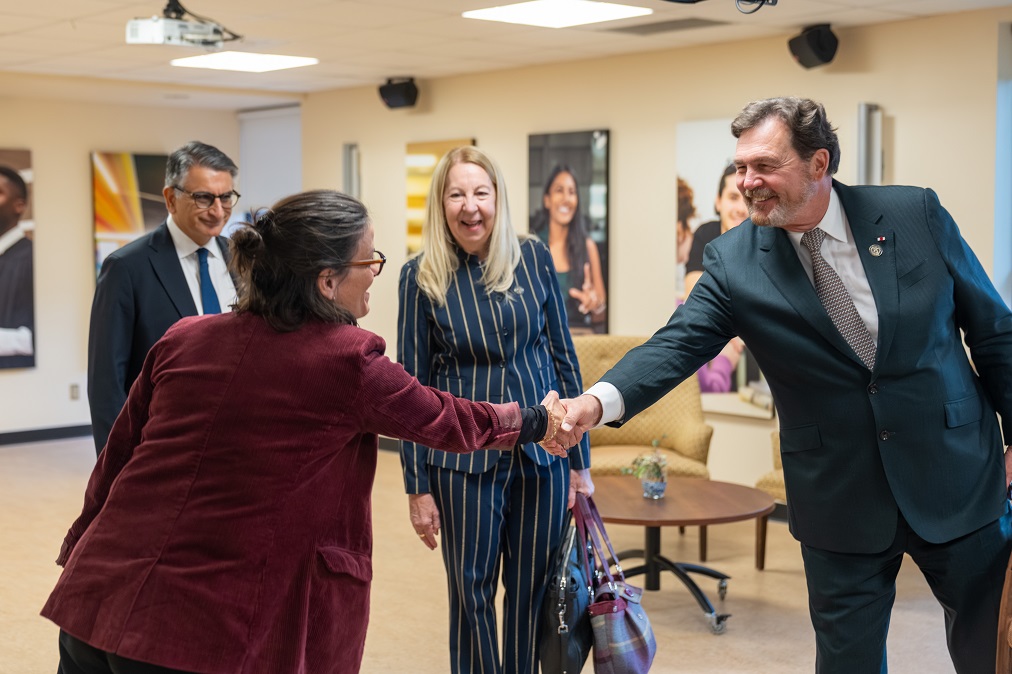 The Chief Justice shakes hands with a representative from Université de Sherbrooke while Justices Jamal and Moreau look on.