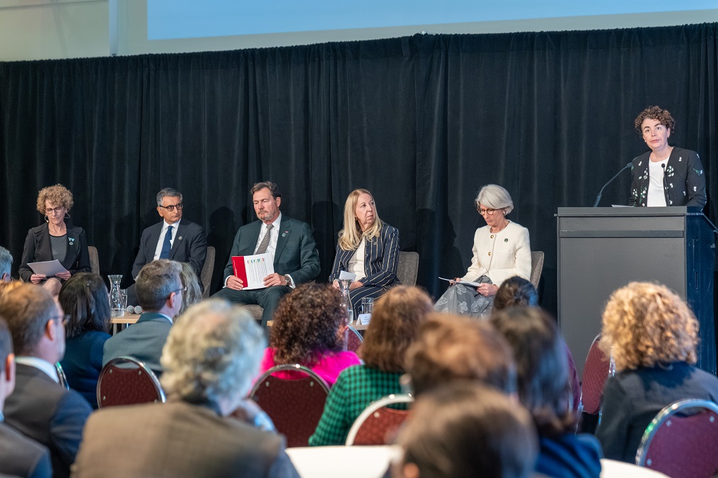 The judges sit on stage with other guests while Marie-Pierre Robert addresses the audience at a reception.
