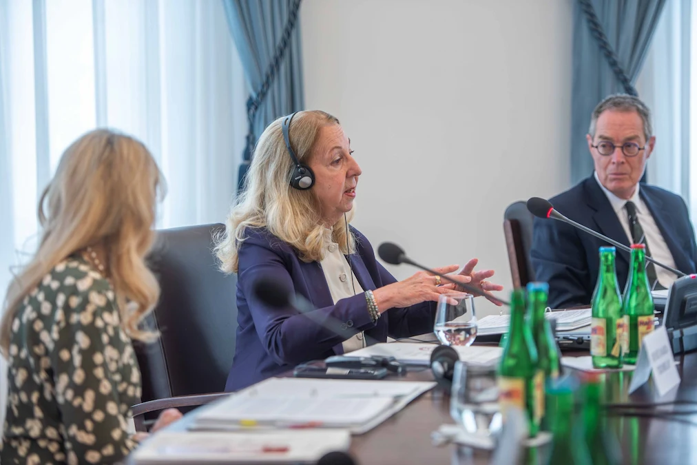 Justice Moreau speaking at a meeting table with Justice Kasirer in the background.
