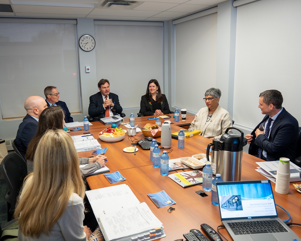 Chief Justice Wagner and Justices Kasirer and O’Bonsawin sitting around a table with employees of the Wellness Court and the Intimate Partner Violence Treatment Option Court.