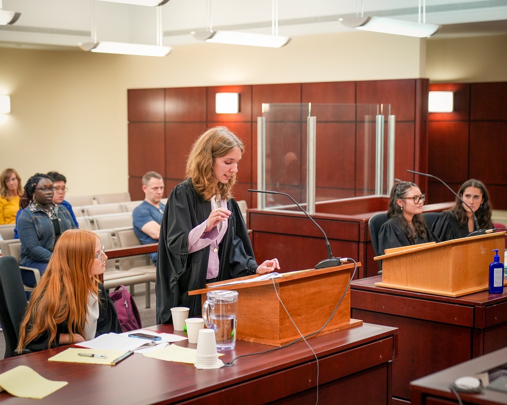 Students from the debate club participating in a mock trial in a courtroom.