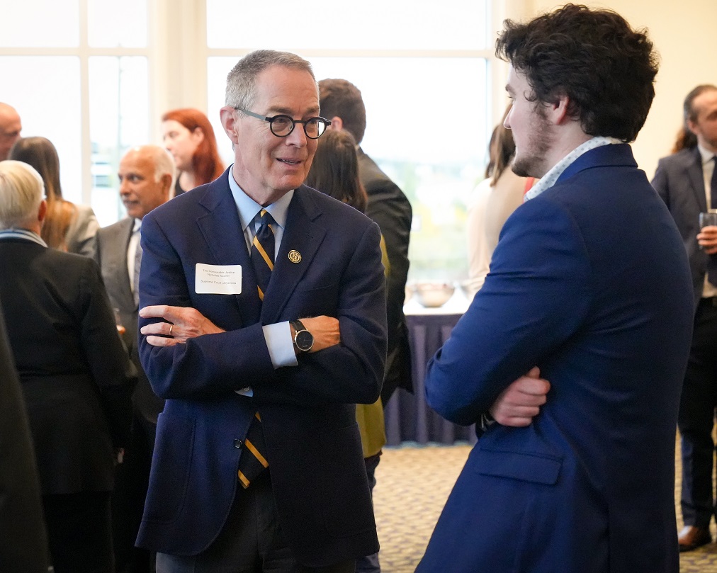 Justice Kasirer speaking to a new lawyer at a reception.