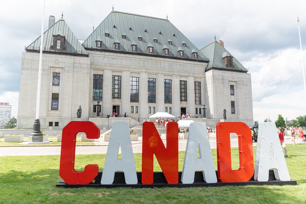 De grandes lettres épellent CANADA sur la pelouse devant l’édifice de la Cour suprême